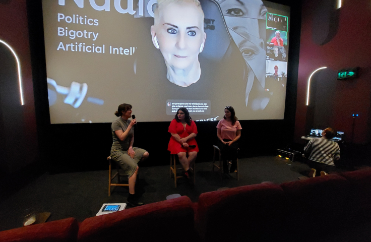 3 people sit in front of a cinema screen 