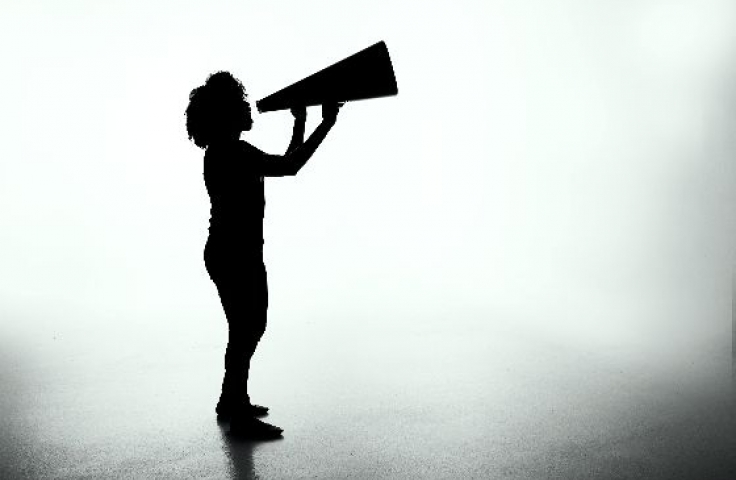 The silhouette of a person speaking into a megaphone