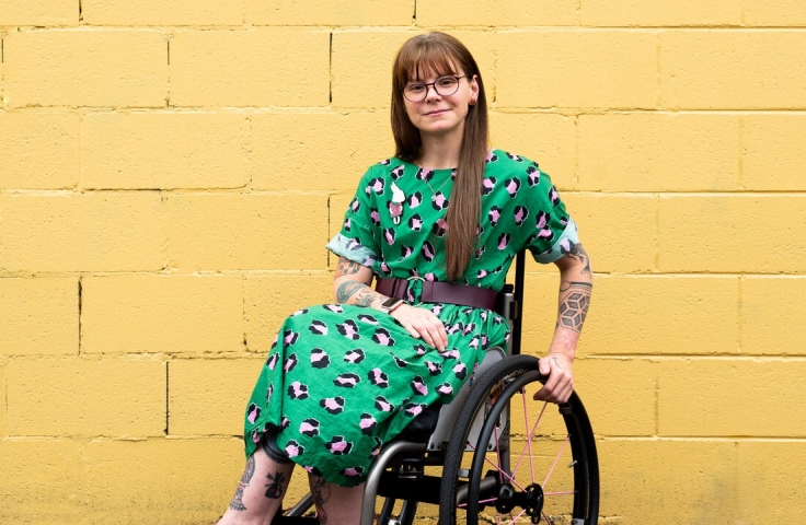 Nicole Lee sites in a wheelchair and smiles for the camera