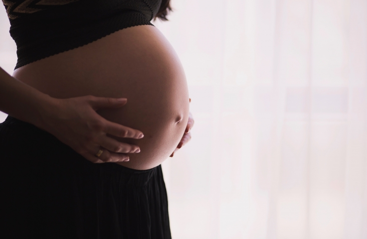 Woman touching her large pregnancy bump