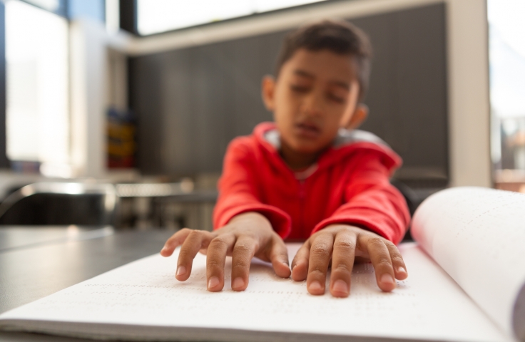 Young boy reading braille 