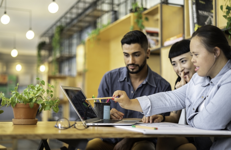 Group of 3 people working at a laptop